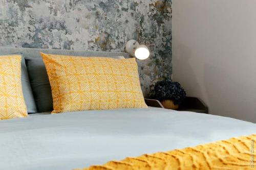 a bedroom with a bed with yellow pillows at Maison « De Ville en Vigne » in Chenôve