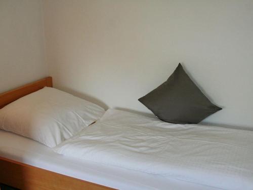 Una cama blanca con una almohada encima. en Luna-Wohnung-12 en Sankt Peter-Ording