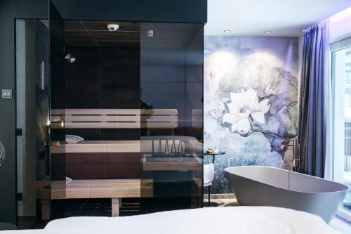 a bathroom with a bath tub and a painting on the wall at Berghotel Hochfügen in Hochfugen