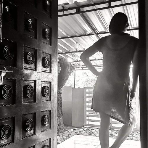 a woman is standing in front of a door at JJ's Holiday Home in Thanniyam