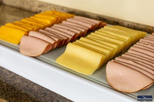 a plate with hot dogs and cheese on a counter at Gaivotas Praia Hotel in Florianópolis