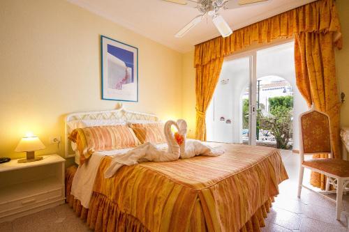 un dormitorio con una cama con un animal de peluche en Ona Los Claveles, en Los Cristianos