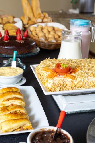 a table topped with different types of food and desserts at Gaivotas Praia Hotel in Florianópolis