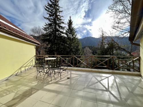 a balcony with a table and chairs on it at Vila Condor in Poiana Brasov