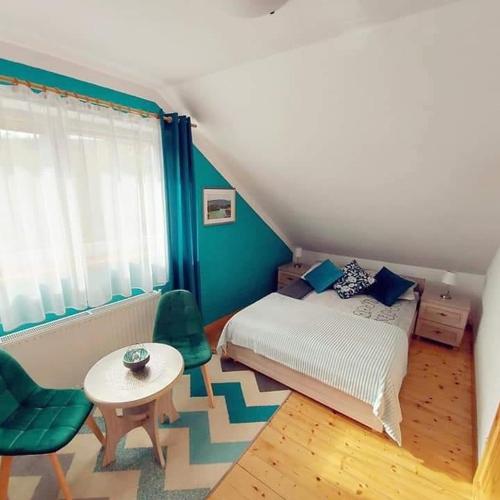 a bedroom with a bed and a table and a chair at Pokoje gościnne "Trudziń-SKI" in Świeradów-Zdrój