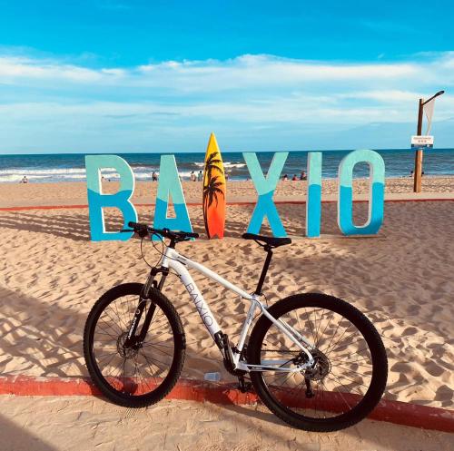 Una bicicleta estacionada en la playa junto a un cartel en Hotel Boutique & Spa Ponta de Inhambupe by Slaviero Hotéis, en Baixio