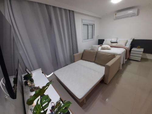 a small bedroom with a bed and a couch at Studio 1202 Guarulhos Aeroporto in Guarulhos