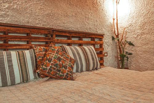 Un dormitorio con una cama con almohadas. en Hobbit village, en Dana