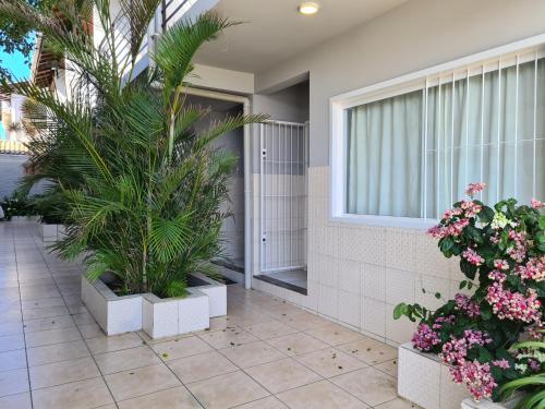 a courtyard with plants and flowers in front of a building at RESIDENCIAL COM CASAS DE 2 DORM - Praia Garopaba in Garopaba
