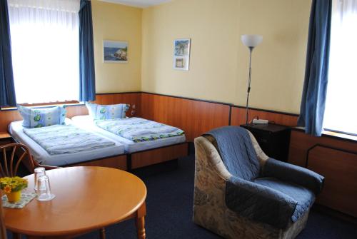 a hotel room with a bed and a chair and a table at Haus Kathrin in Zecherin