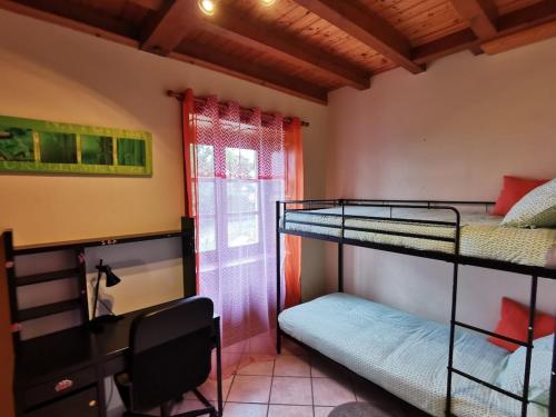 1 dormitorio con 2 literas y ventana en Gite du platane, en Grazac