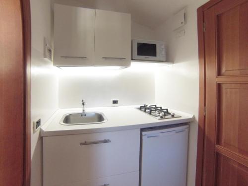 uma pequena cozinha com um lavatório e um micro-ondas em casaisoladelba em Lacona