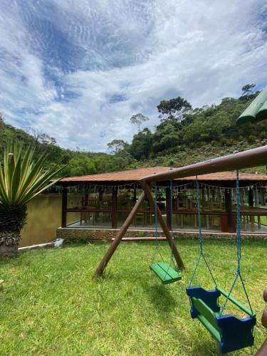 a swing in the yard of a building at Hotel Fazenda Bonanza in Engenheiro Paulo de Frontin