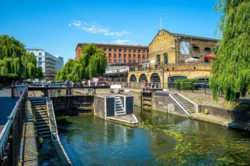 a river in a city with a bridge and buildings at Fabulous Studio Apartment Camden in London