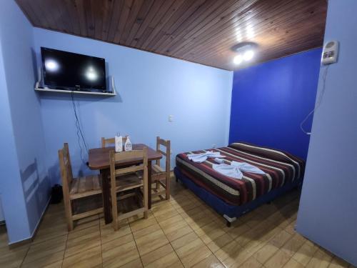 a room with a bed and a table and a tv at Rinconcito Iguazú in Puerto Iguazú