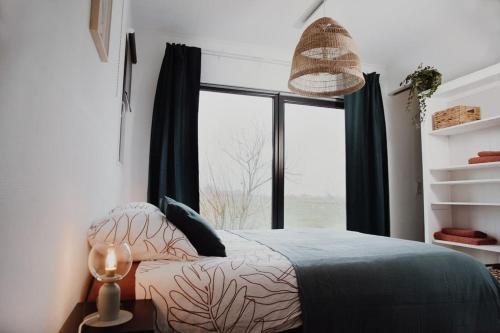 a bedroom with a bed and a large window at De Veenweide in De Veenhoop