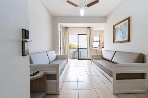 a living room with couches and a tv at Gaivotas Praia Hotel in Florianópolis