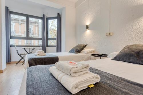 a hotel room with two beds with towels on them at HOSTAL BEDMATES in Barcelona