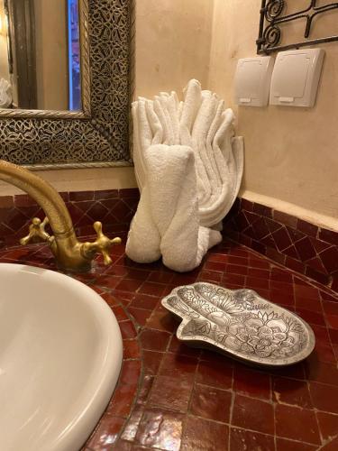 馬拉喀什的住宿－Riad au cœur de la médina loué entièrement avec ménage et petit déjeuner compris，地板上设有带水槽和毛巾的浴室