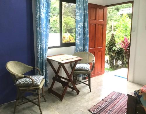 una mesa y dos sillas frente a una puerta en Casa Girasol, en Puerto Viejo