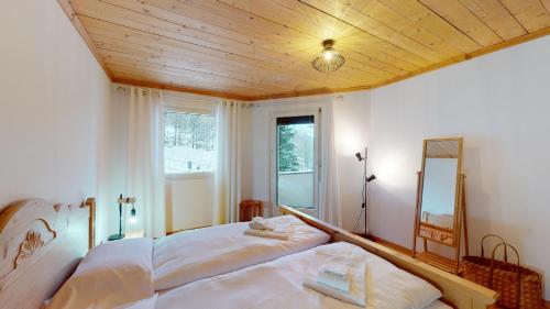 a bedroom with a large bed and a mirror at Abitaziun Ruinatsch 22 - St Moritz in St. Moritz
