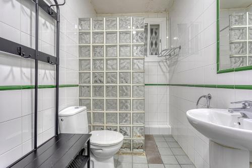 a white bathroom with a toilet and a sink at HOSTAL BEDMATES in Barcelona
