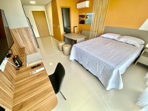 1 dormitorio con 1 cama, 1 silla y TV en Edifício SKY Apto 810 - ER Hospedagens, en Maceió