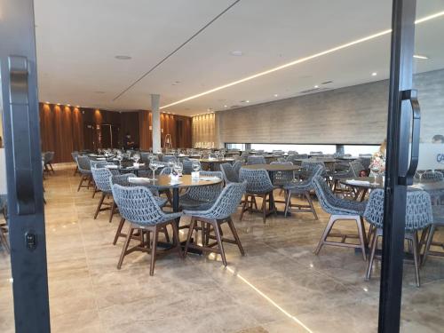 a restaurant with tables and chairs in a room at Salinas Premium Resort in Salinópolis