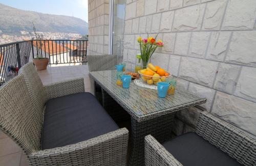 a table with a bowl of fruit on a balcony at Apartment Lana in Dubrovnik