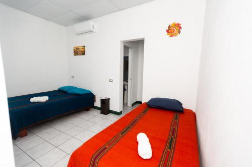 a room with a bed and a red blanket at Hotel Villas Lucciana in El Paredón Buena Vista