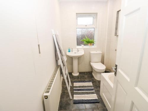 a white bathroom with a sink and a toilet at Maple House in Tadcaster