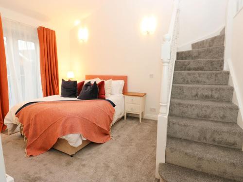 a bedroom with a bed and a staircase at Maple House in Tadcaster