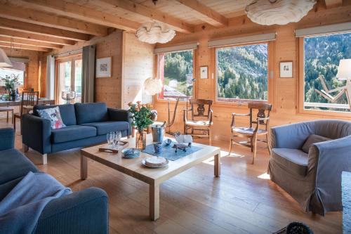 a living room with blue couches and a table at Chalet Le Charmieux - OVO Network in Le Grand-Bornand