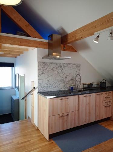 a kitchen with wooden cabinets and a sink at Ferienhaus am Bach in Achslach