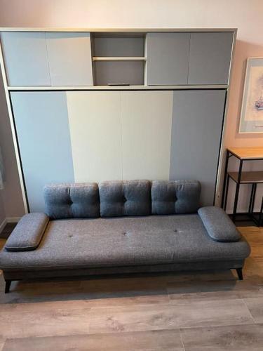 a couch sitting in front of a wall at Cambrai splendide studio au calme in Cambrai