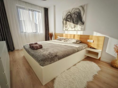 a bedroom with a large bed and a rug at Cluj Airport Apartment in Cluj-Napoca