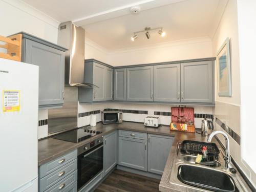a kitchen with blue cabinets and a sink at The Link in Torquay