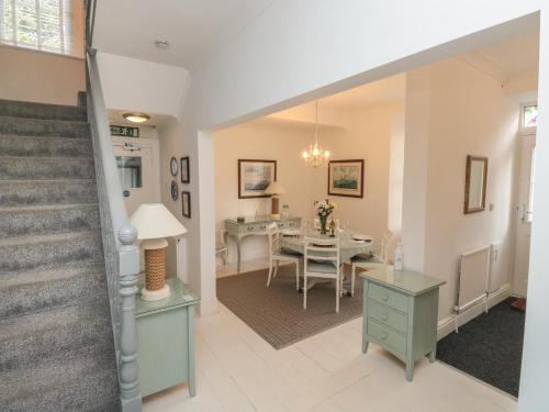 a living room with a staircase and a dining room at The Link in Torquay