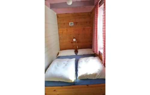 two beds in a room with wooden walls at Sjhytta in Vanvik