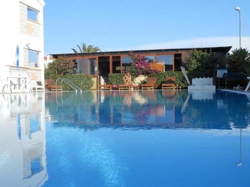 una piscina con acqua blu di fronte a un edificio di B&B La Posada Stintino a Stintino