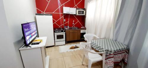 una pequeña cocina con mesa y un ordenador en un escritorio en KITNET S2 em TORRES-RS - Na mais bela praia Gaúcha - Cozinha - Banheiro - Ar condicionado - TV - Wi-Fi - Estacionamento - Acomoda até 6 pessoas - Anfitriã Superhost no BnB, en Torres