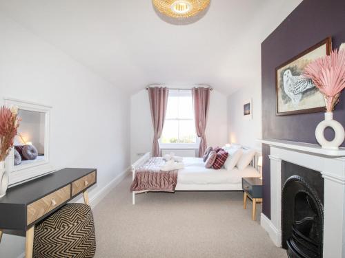 een slaapkamer met een bed en een open haard bij Wolf Cottage in Weymouth