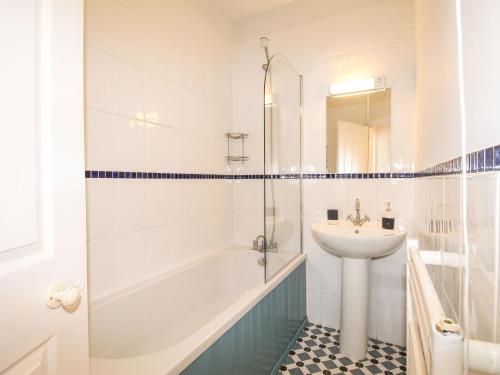 een witte badkamer met een wastafel, een bad en een toilet bij Wolf Cottage in Weymouth