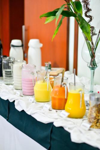 a table with many jars of different colored candles at Hotel Plaza Mar in Vila Velha