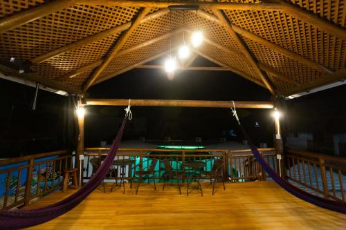 a room with a table and chairs and hammocks at Hotel Villas Lucciana in El Paredón Buena Vista