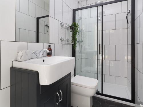 a bathroom with a sink and a toilet and a shower at Wansfell at Lipwood House in Windermere