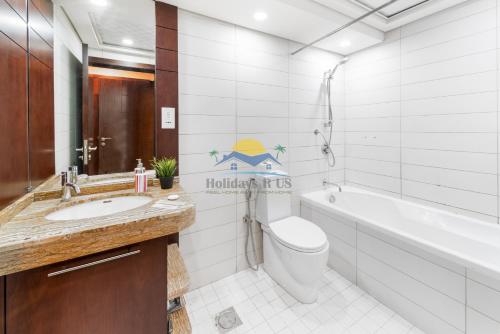La salle de bains est pourvue de toilettes, d'un lavabo et d'une baignoire. dans l'établissement Holidays R Us canal view, à Dubaï