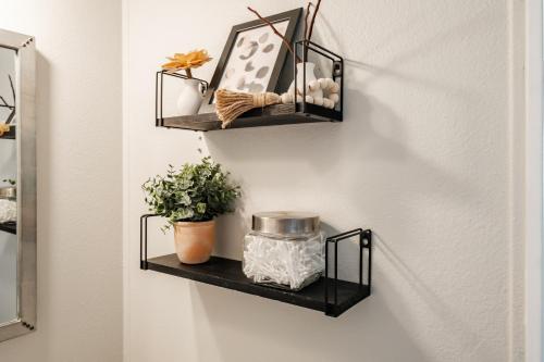 a black shelf with plants and a picture on a wall at Renovated Bungalow Getaway in Philomath