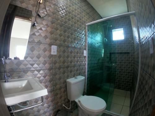 ein Bad mit einem WC, einer Dusche und einem Waschbecken in der Unterkunft Casa para Família com Piscina in Luis Correia