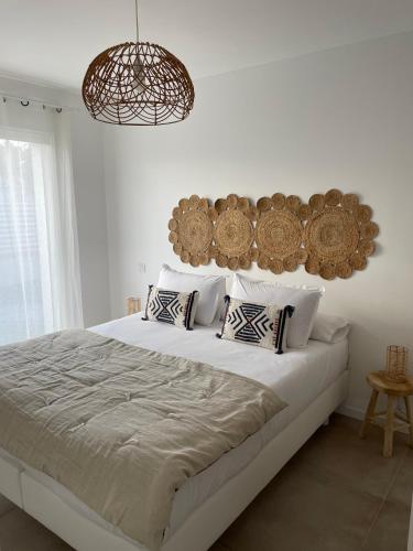 une chambre blanche avec un grand lit avec des oreillers dans l'établissement Les Lodges de Saint Brice 1, à Arès